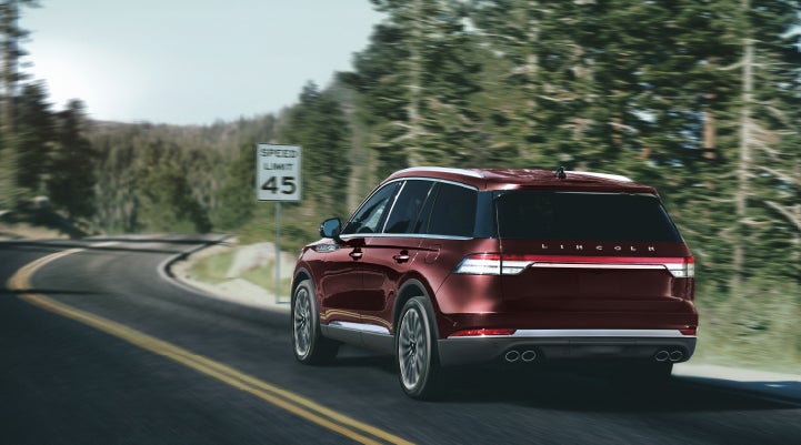 A 2024 Lincoln Aviator® SUV is being driven on a winding mountain road | Dave Sinclair Lincoln in St Louis MO
